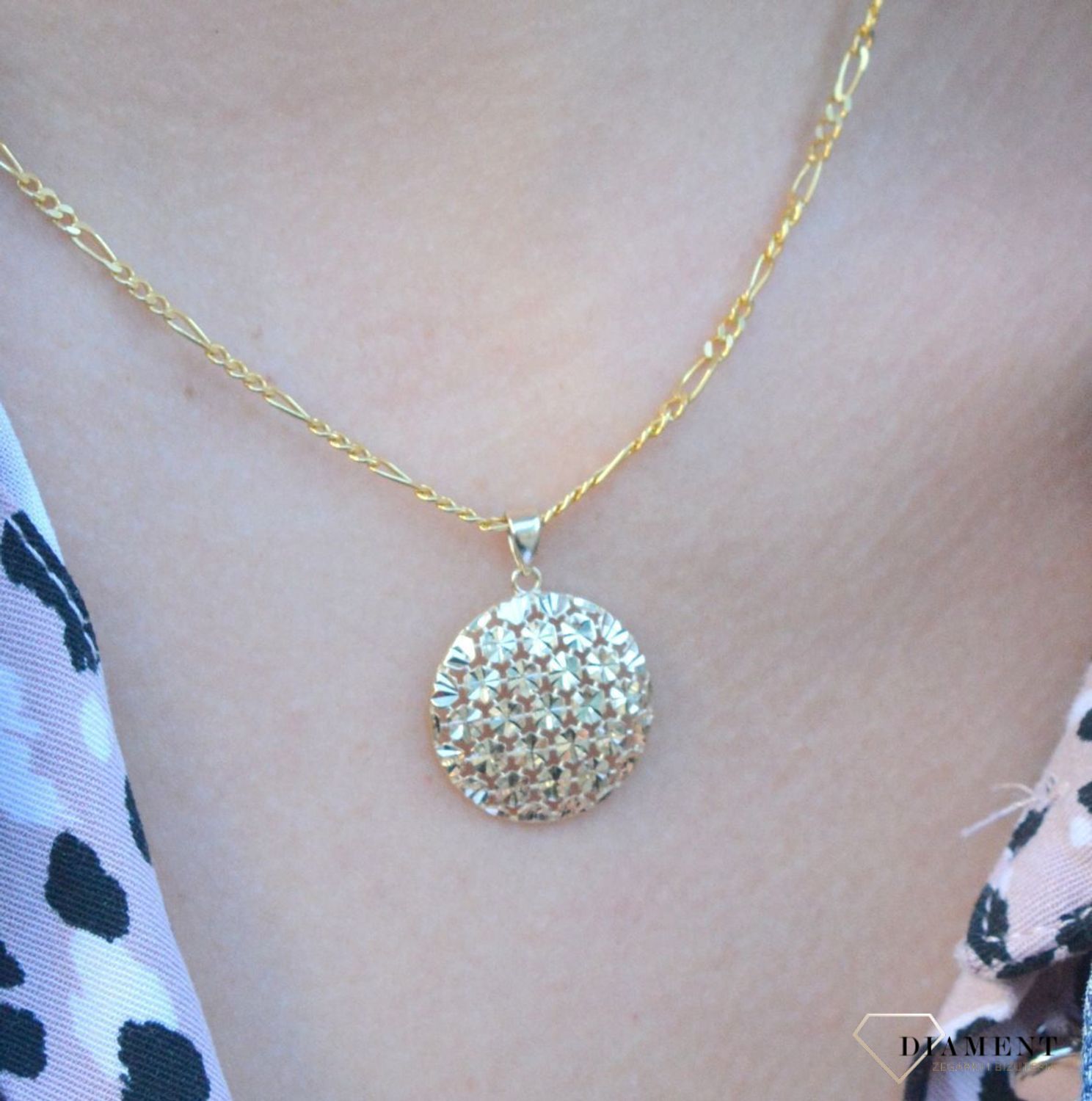 Złota zawieszka 333 okrągły ażur ZA 7020 333. Złoty wisiorek w kształcie koła wypełniony ażurowym motywem. Wisiorek o minimalistycznym wzornictwie, ale jednocześnie o ogromnym znaczeniu symbolicznym. Złoto jest metalem szlach.jpg